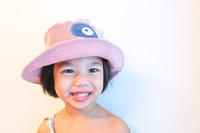 Portrait of cute girl wearing hat against white background