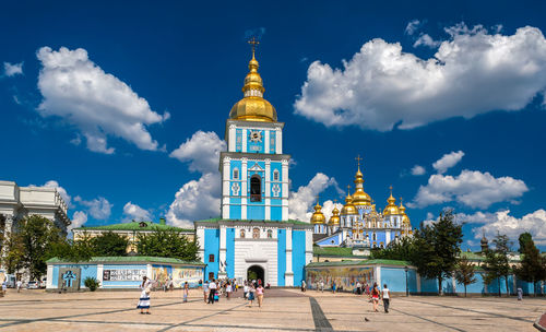 View of buildings in city against cloudy sky