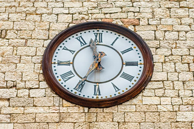 Close-up of clock on stone wall