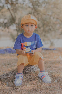 Portrait of toddler sitting on field