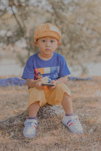 Portrait of boy sitting on field