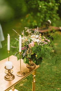 Flower vase on table against plants