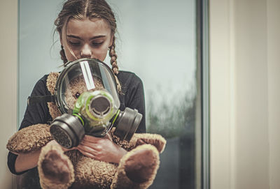 Woman looking through window at home