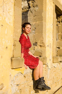 Full length of smiling woman against wall