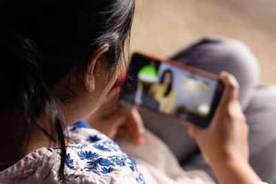 An indian woman with smart phone enjoying ott application at home