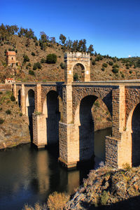 Arch bridge over river against sky