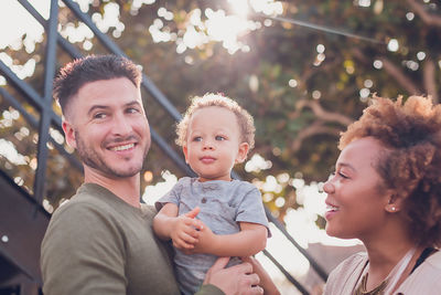 Dad holding baby boy and mom looking at baby