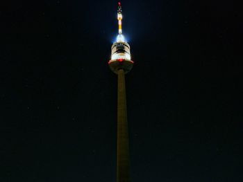 Low angle view of illuminated tower against sky at night