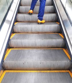 Low section of person on escalator