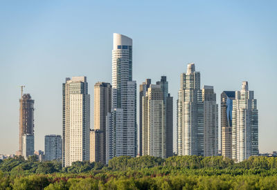 Modern buildings in city against clear sky