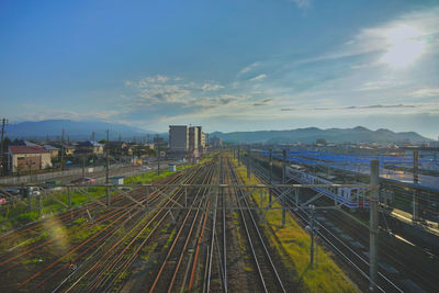 High angle view of railroad tracks amidst buildings against sky