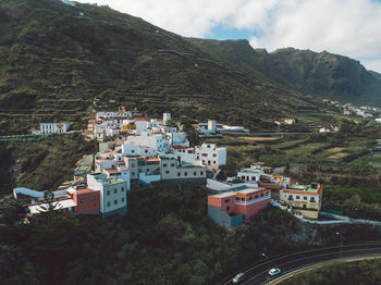 High angle view of townscape by mountain against sky