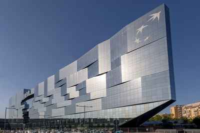 Low angle view of modern building against clear blue sky