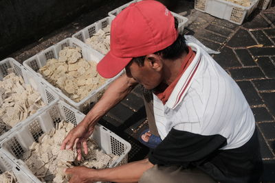 High angle view of man putting food in basket