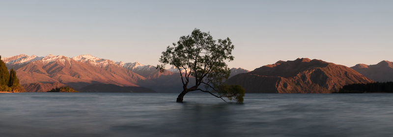 Scenic view of lake and mountains against clear sky