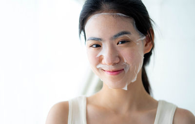 Close-up of young woman against white background