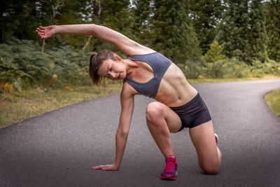 Full length of woman sitting on road