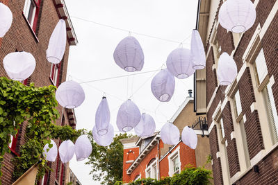 Low angle view of lanterns hanging amidst buildings in city