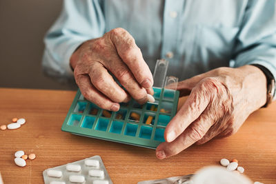 Senior man organizing his medication into pill dispenser. healthcare and old age concept