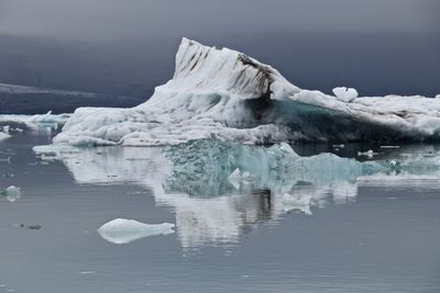 Glaciers in sea against sky