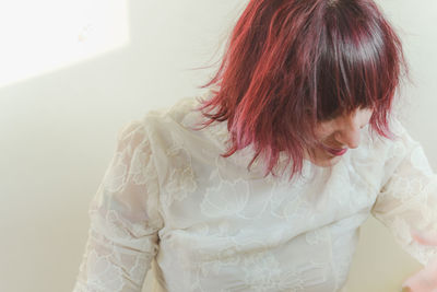 Rear view of woman standing against wall