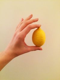 Cropped image of hand holding face over white background