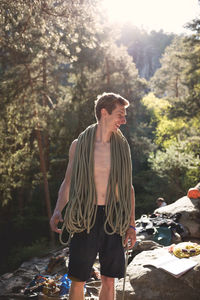 Young man standing on table against trees