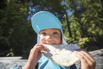 Boy snacking on pita bread, eating lunch at the beach.