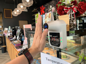 Cropped hand of woman holding christmas tree