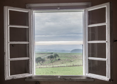 Scenic view of field seen through window