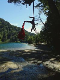 Man jumping hanging from tree