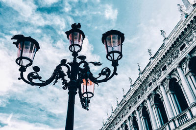 Low angle view of street light against cloudy sky