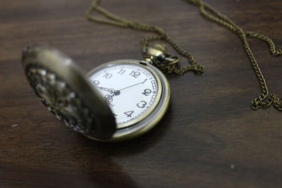 Close-up of pocket watch on wooden table