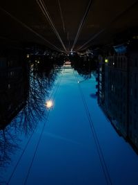 Upside down photo of street against blue sky at night