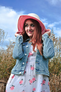 Portrait of beautiful young woman standing against wall