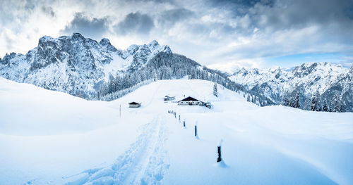 Scenic view of snowcapped mountains against cloudy sky