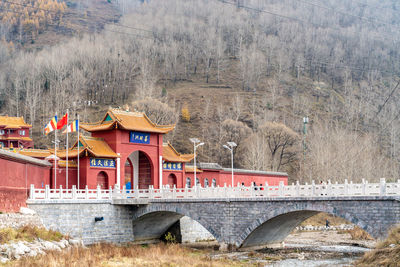 Arch bridge over river against trees