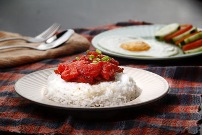 Freshly cooked filipino food called tocino or cured pork meat   served with rice, egg and veggies