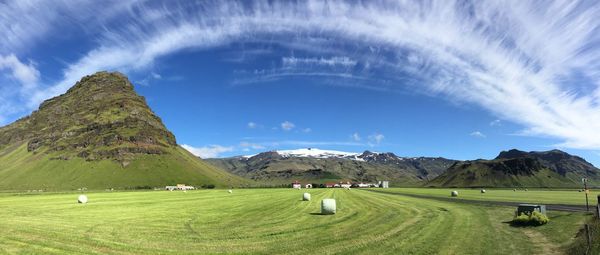 Scenic view of grassy field against cloudy sky