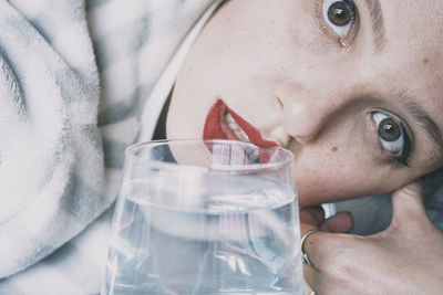 Close-up portrait of woman holding glass of water