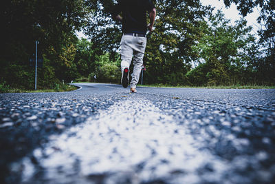 Low section of person walking on road