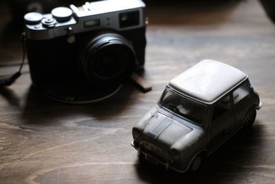 High angle view of toy car and camera on table