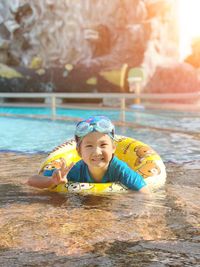 Portrait of smiling cute girl swimming in pool