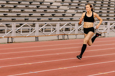 Full length of woman exercising on playing field