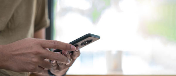 Midsection of man using mobile phone