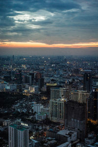 High angle view of city lit up at sunset