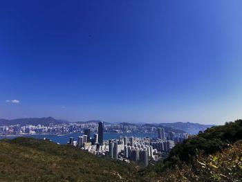 Scenic view of buildings in city against clear blue sky