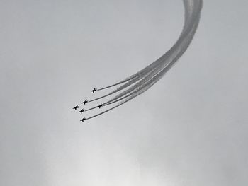 Low angle view of airplane against sky over white background