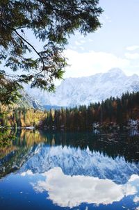 Snow covered mountains reflected in the italian lake laghi di fusine.