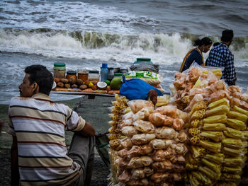 Rear view of people sitting at beach